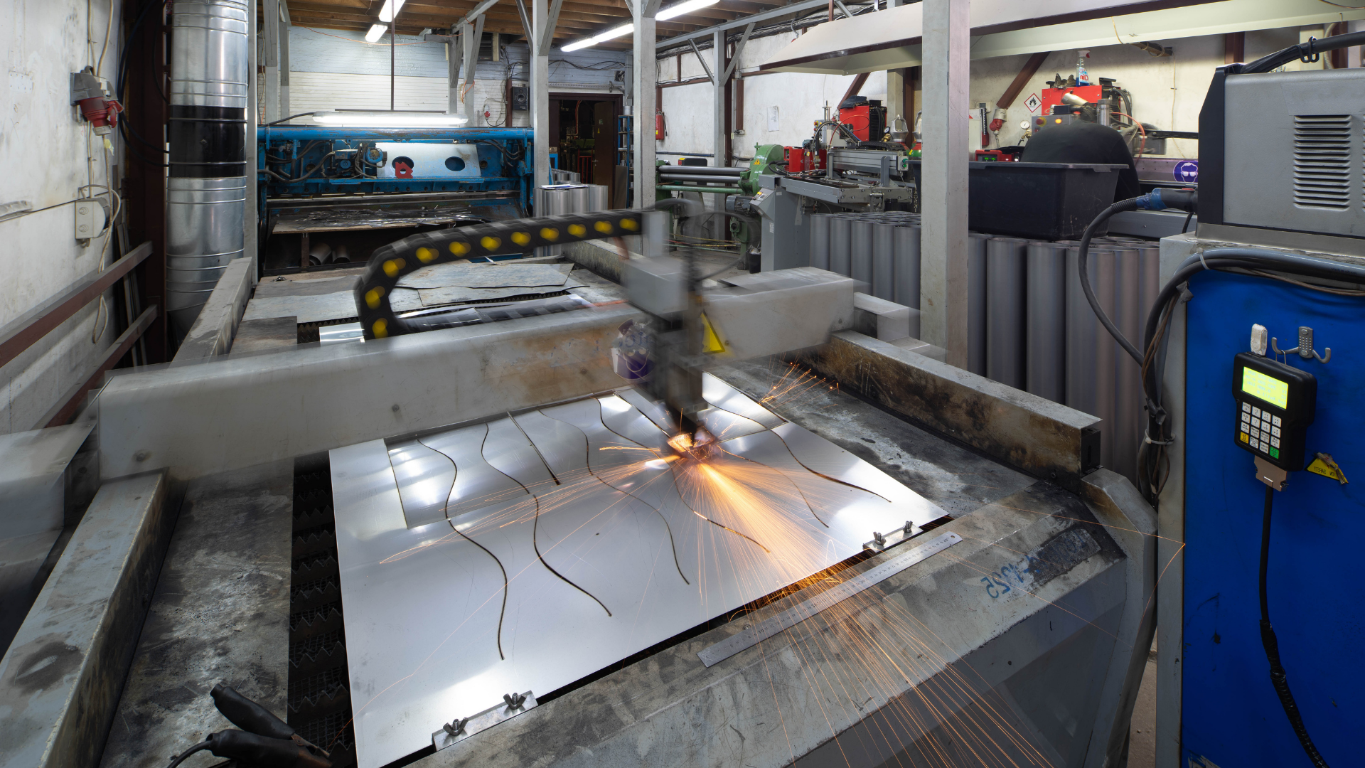 Person welding metal beams, with bright sparks flying in a workshop.