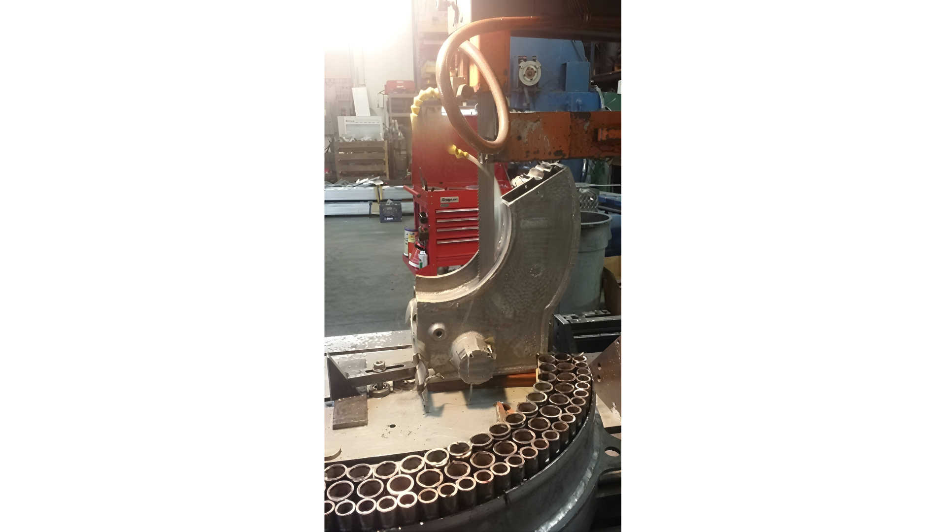 Close-up of a red and blue mechanical sculpture on a circular base in a workshop or exhibit.