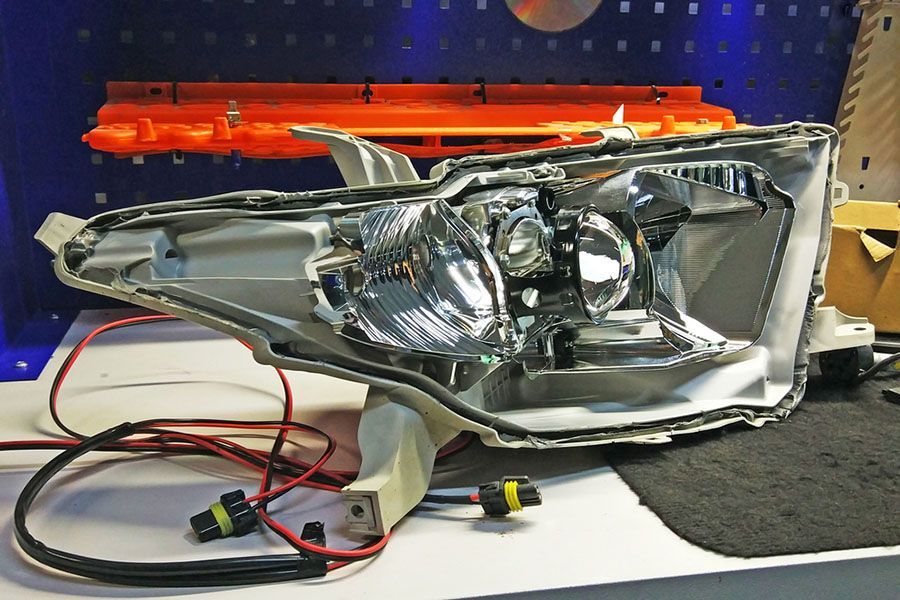 A Car Headlight Is Sitting On A Table With Wires Attached To It — Hansens Auto Electrical In Bundaberg Central, QLD