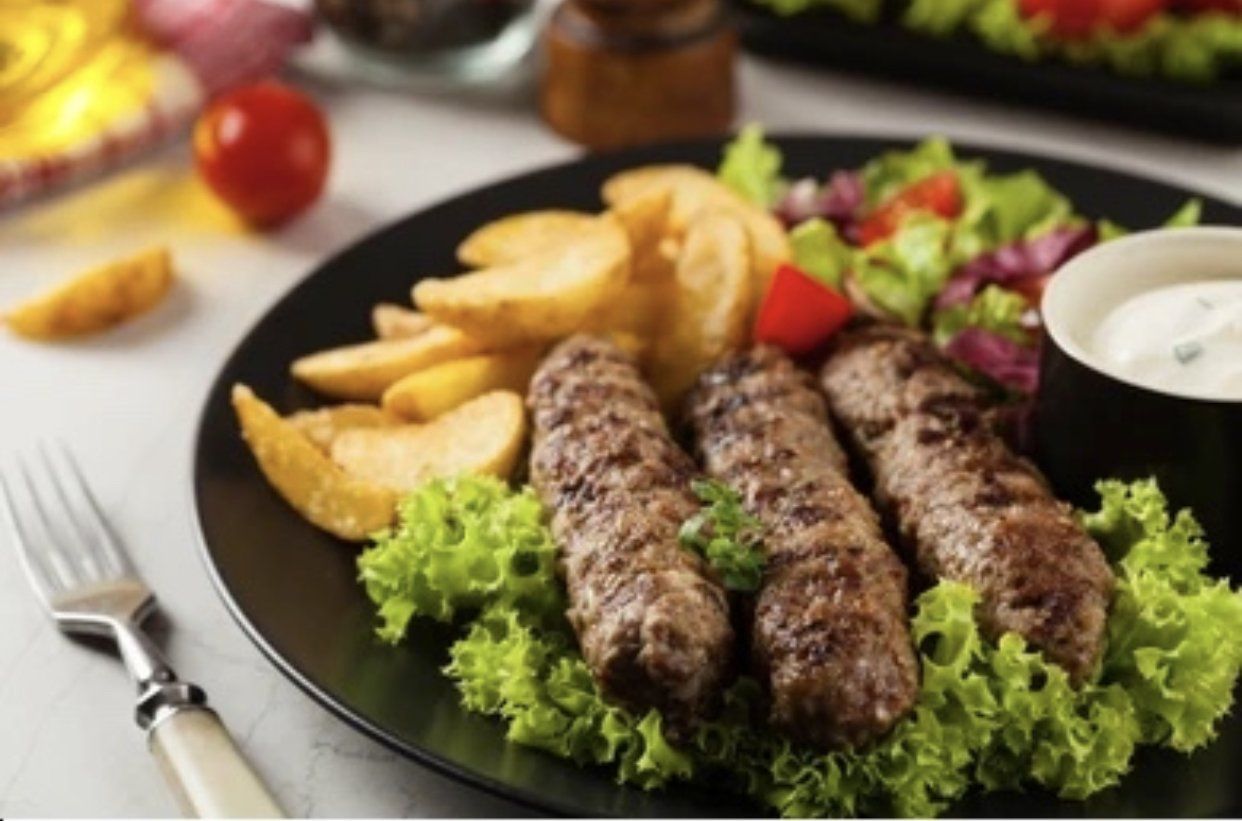 Ein Teller mit Fleisch und Pommes Frites darauf