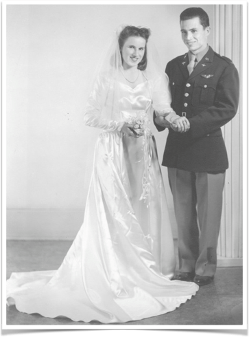 A black and white photo of a bride and groom holding hands