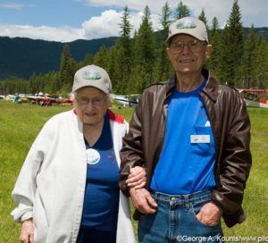 A man and a woman are posing for a picture in a field.