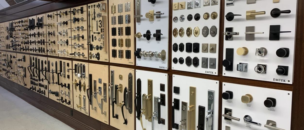 Wall display of various door handles and hardware samples in a store.