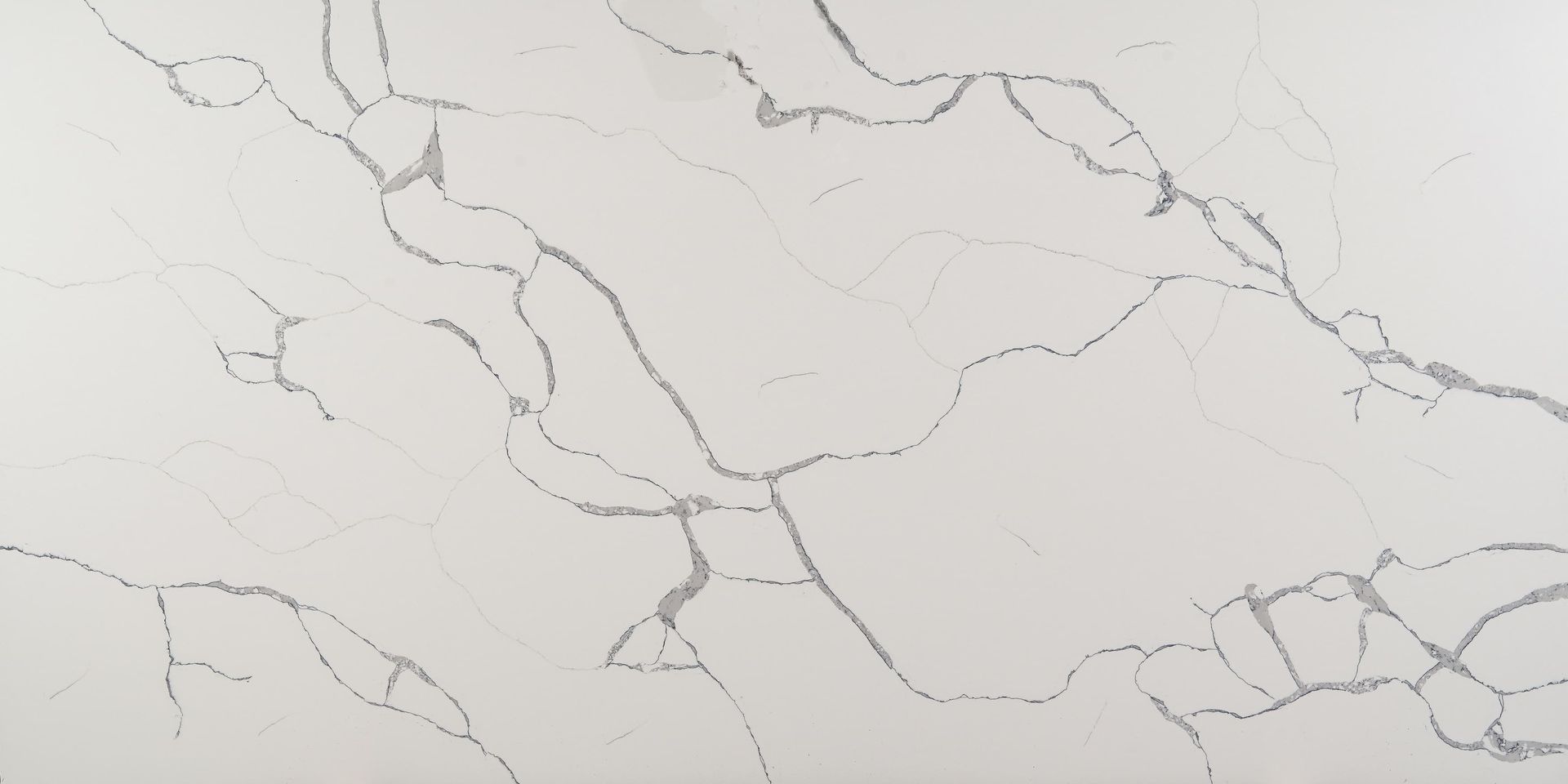 A close up of a white quartz counter top with a marble texture.
