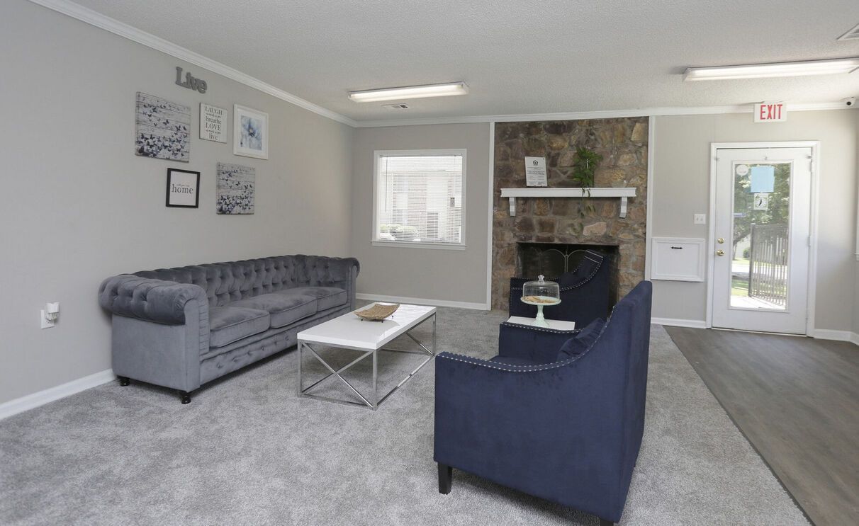 A living room with a couch , chair , coffee table and fireplace.