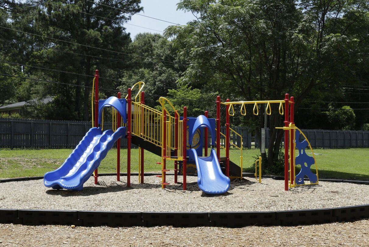 A playground with blue slides and a swing set