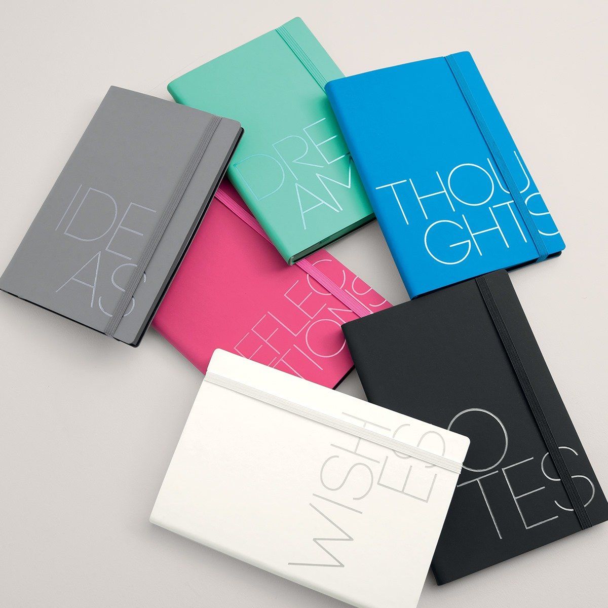 Sette quaderni colorati con testo: