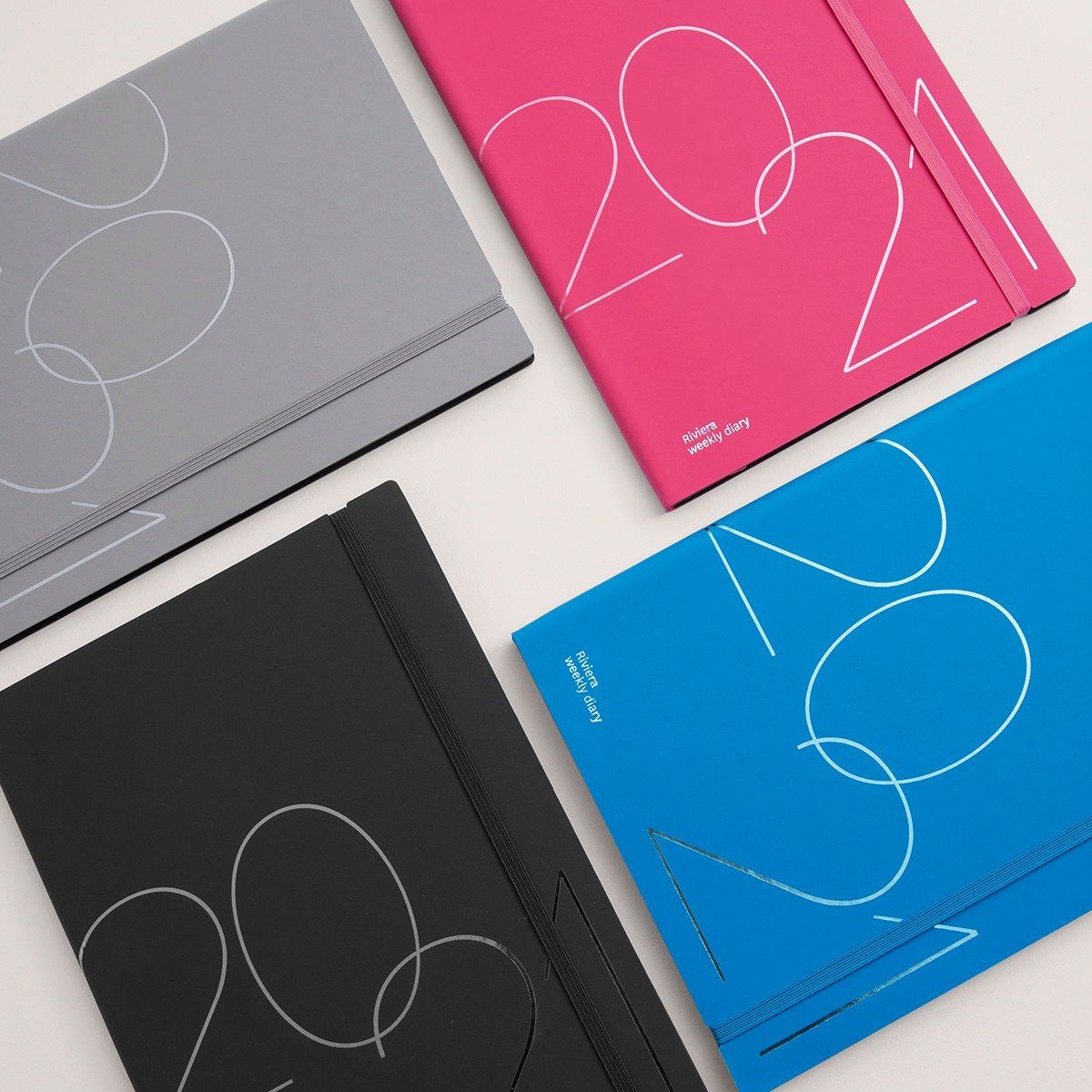 Quattro colorate agende 2021: grigio, rosa, nero e blu, con la scritta