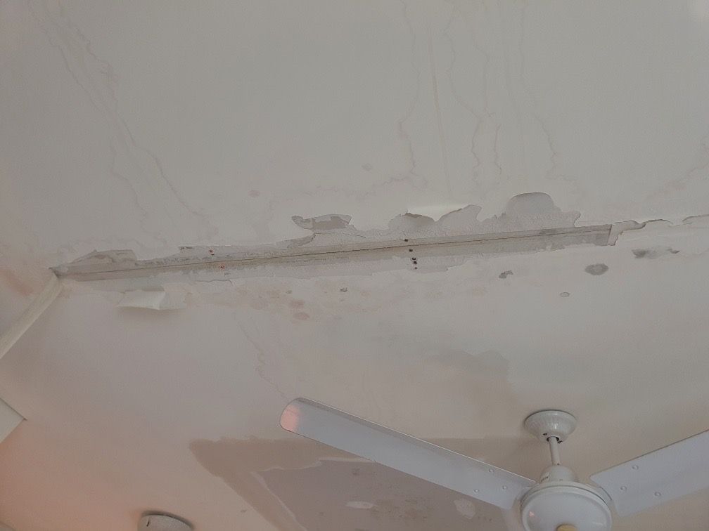 White ceiling with peeling paint and a ceiling fan — Patch Plaster Paint in Johnston, NT