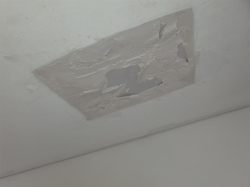 Patch of peeling paint on a white ceiling, revealing a hole — Patch Plaster Paint in Johnston, NT