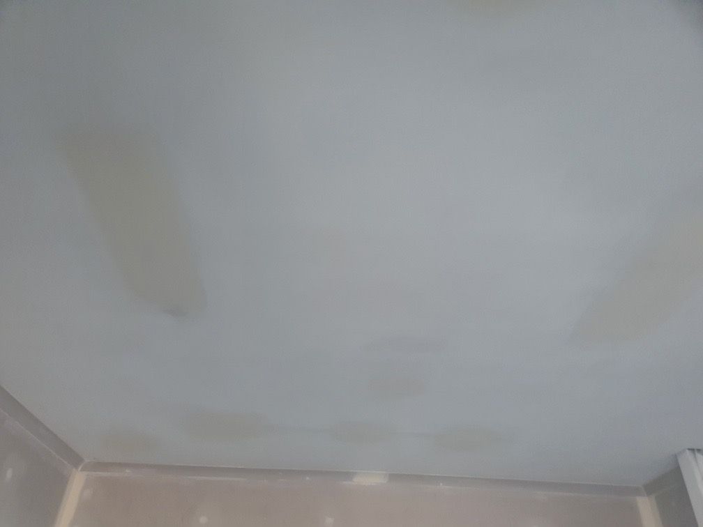 Off-white ceiling with several darker stains, likely water damage, above a light-coloured wall — Patch Plaster Paint in Johnston, NT
