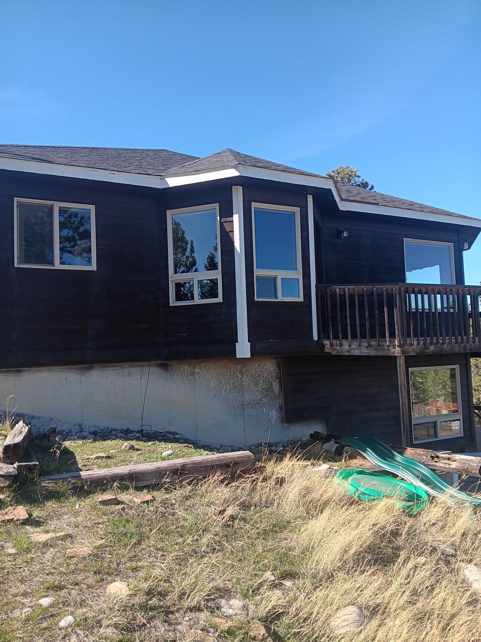 Dark blue house with a small porch and white trim on a sunny day