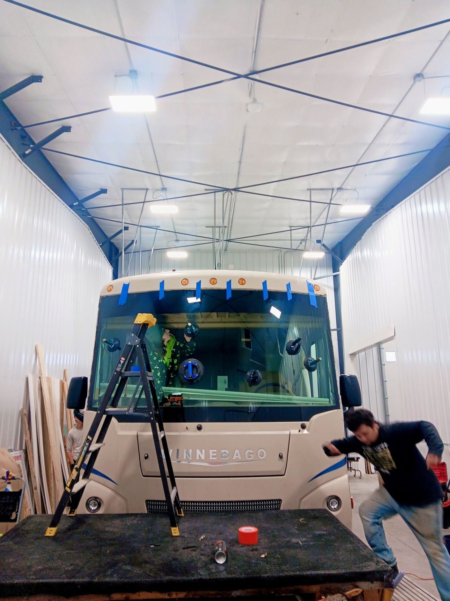 Truck being cleaned in a wash bay, with workers on the front and side of the vehicle.