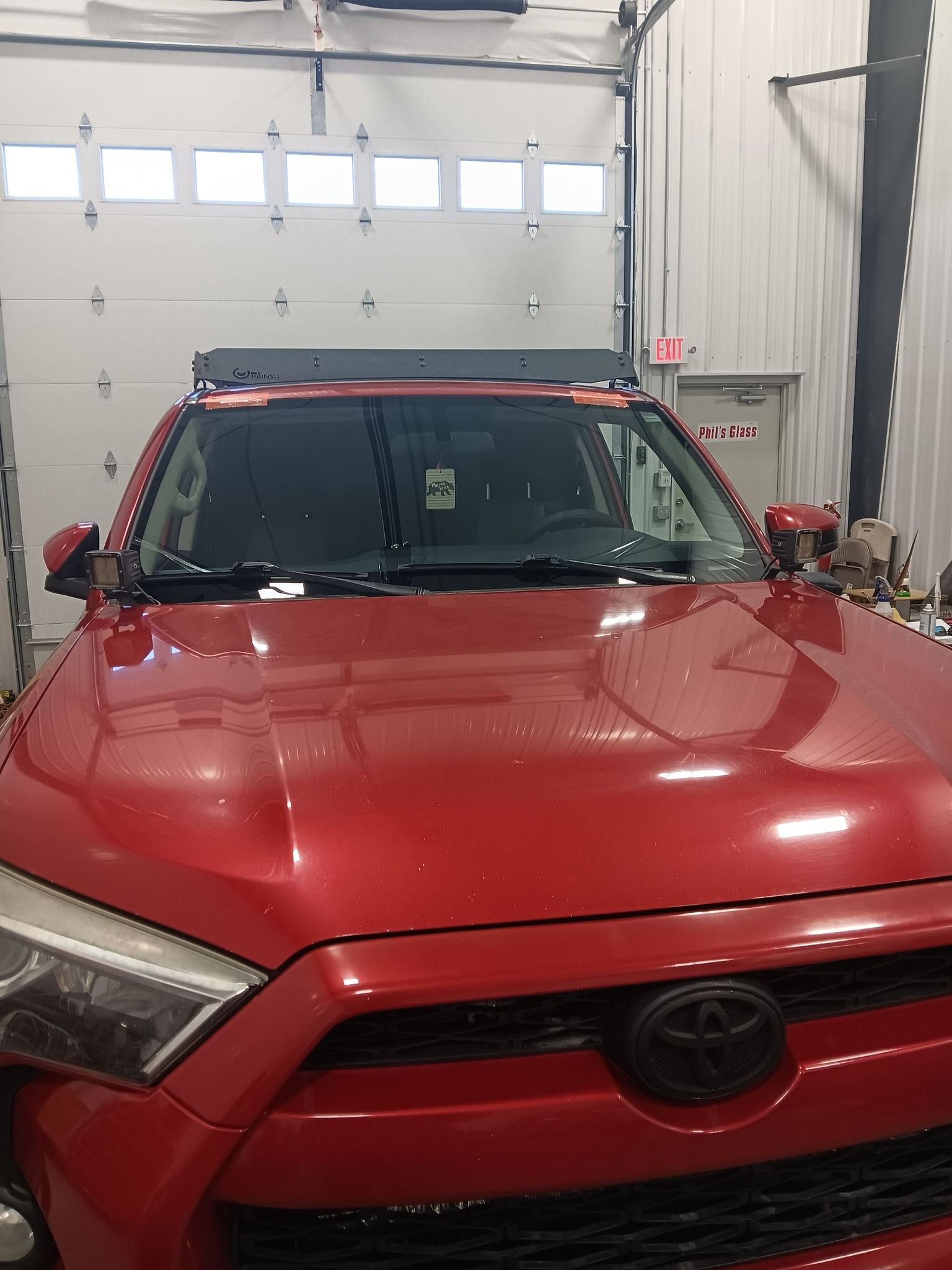 Red Toyota SUV parked inside a garage, viewed from the front.