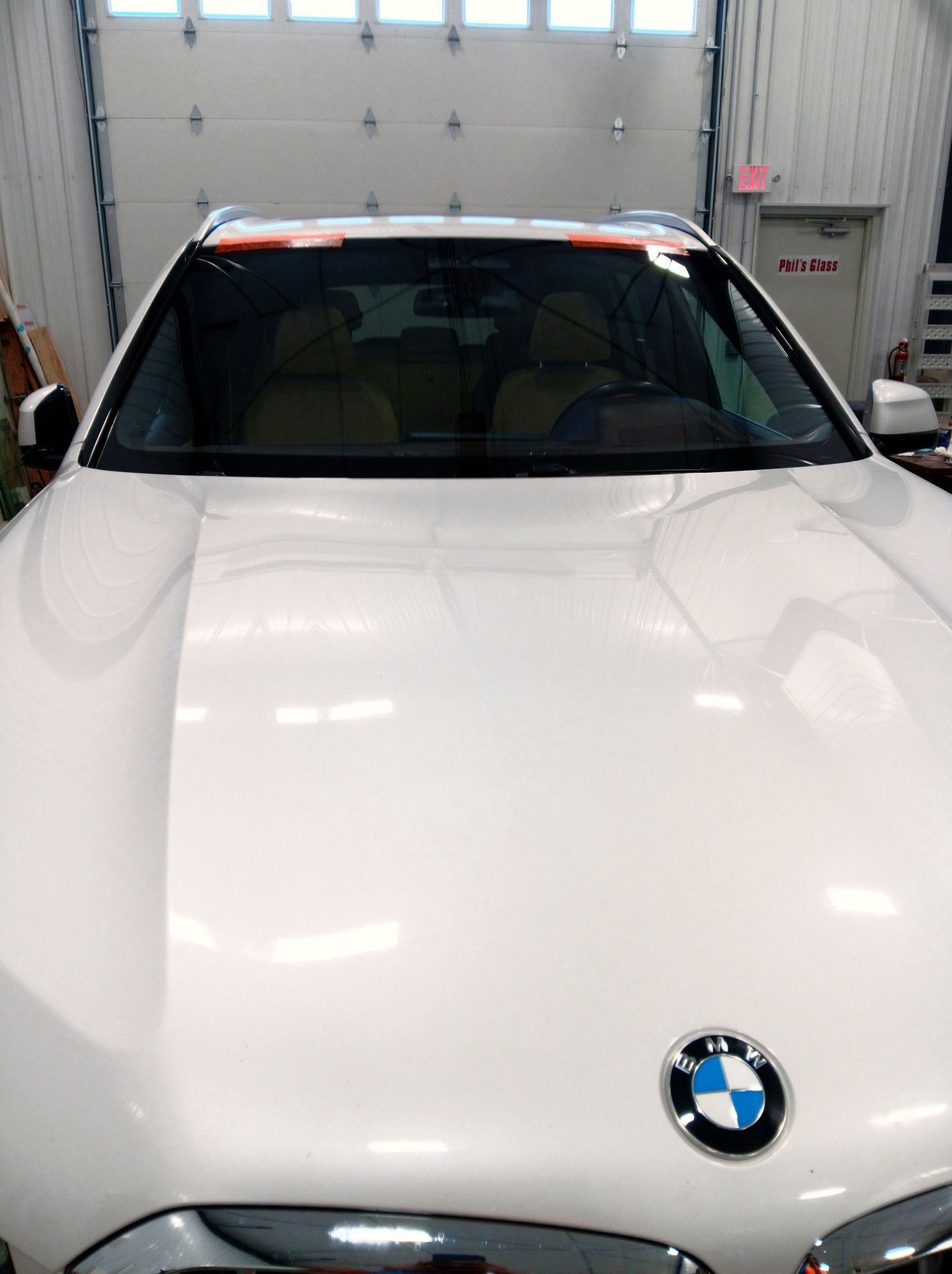 White BMW parked in a garage, front view.