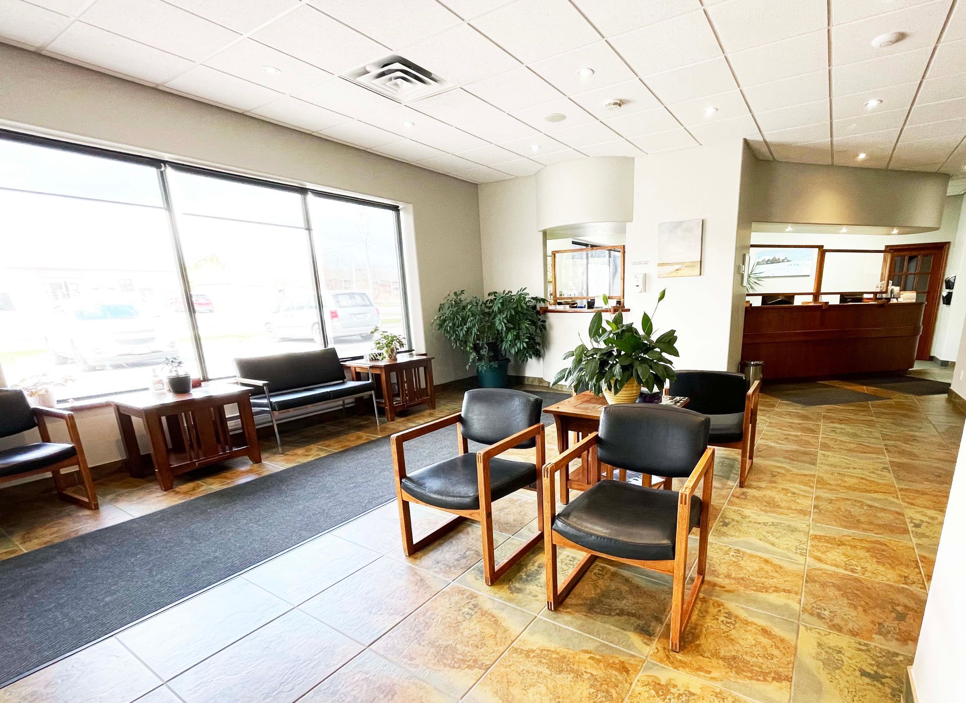 A waiting room with chairs , tables and a couch.