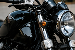 Close-up of a black motorcycle with chrome details and a round headlight
