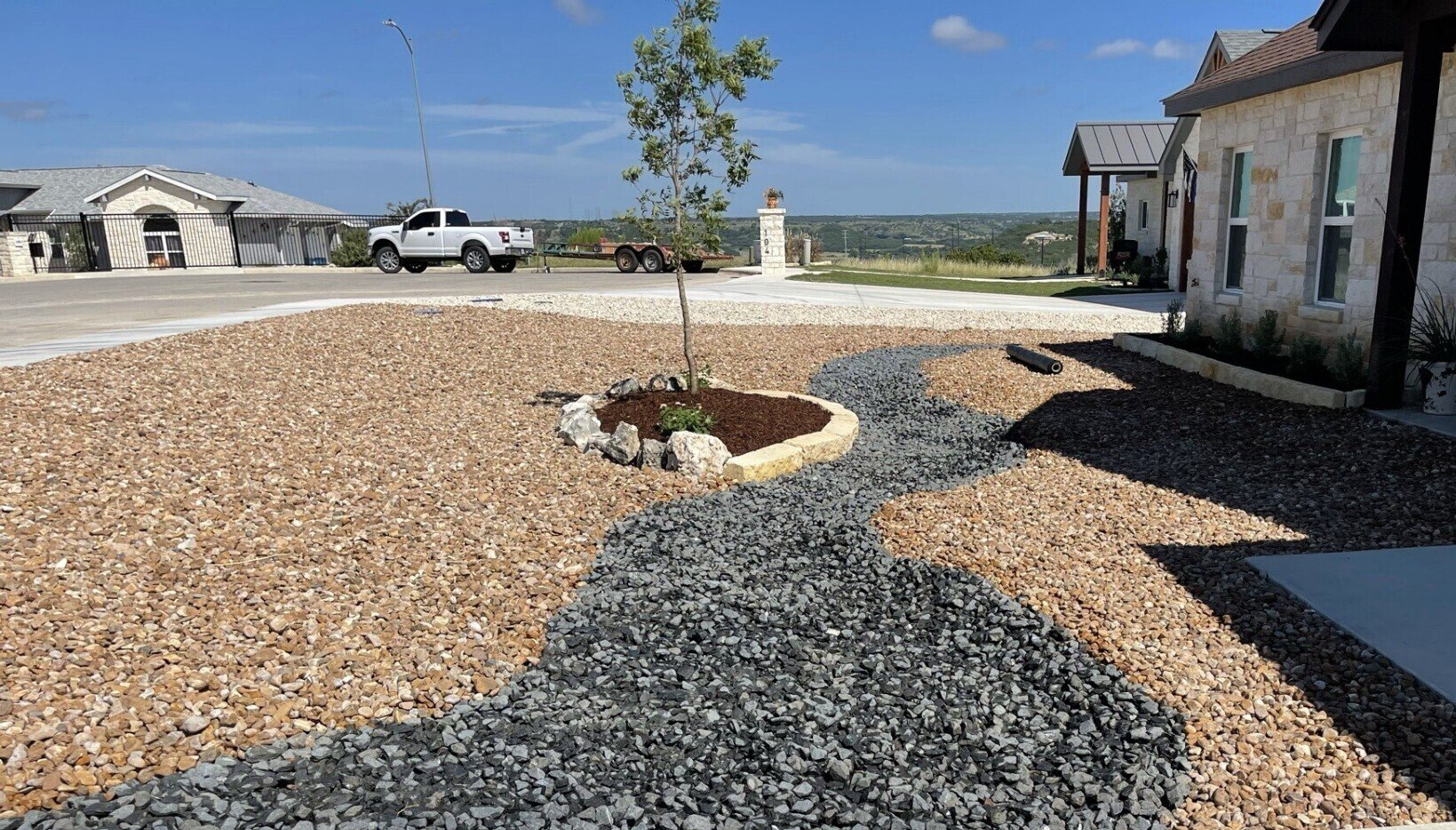 Planter - Tree in  middle of zeroscaped yard with circle of stones 