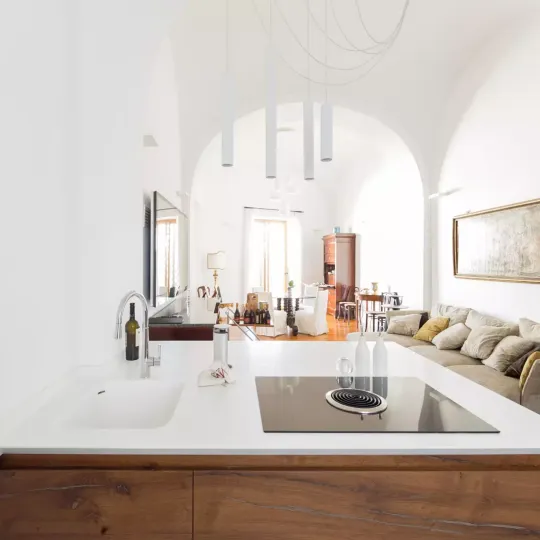 Soggiorno moderno con divano angolare color beige, grande TV a parete e finestre a tutta altezza.