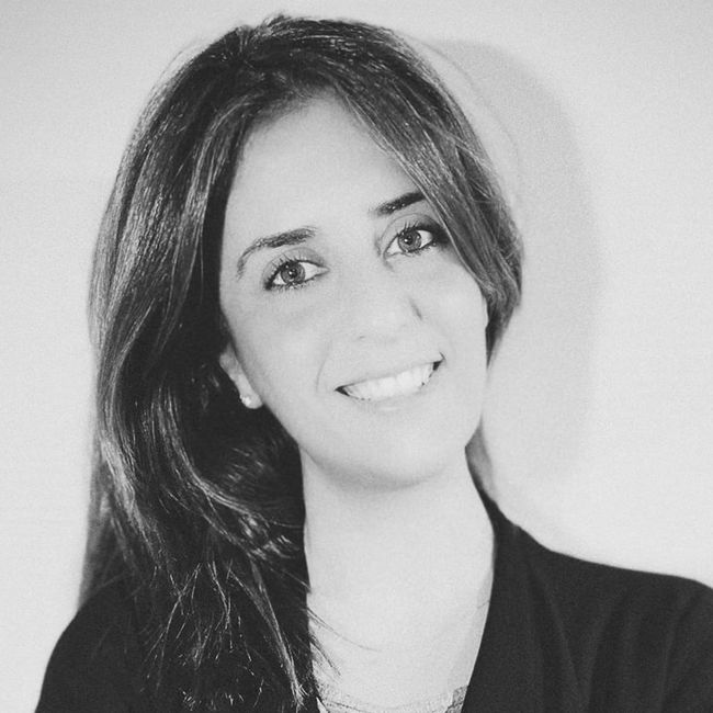 Donna sorridente con lunghi capelli scuri su sfondo chiaro