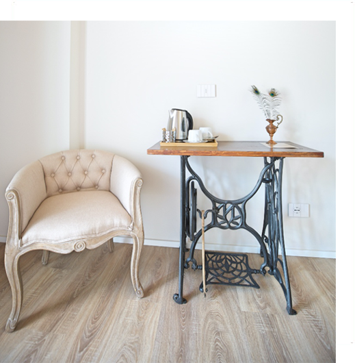 Luminoso bagno in marmo con vasca freestanding, finestra, mobile lavabo e cornice dello specchio turchese.
