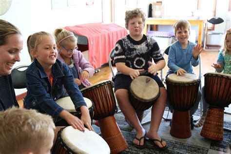 Children are sitting around and drumming