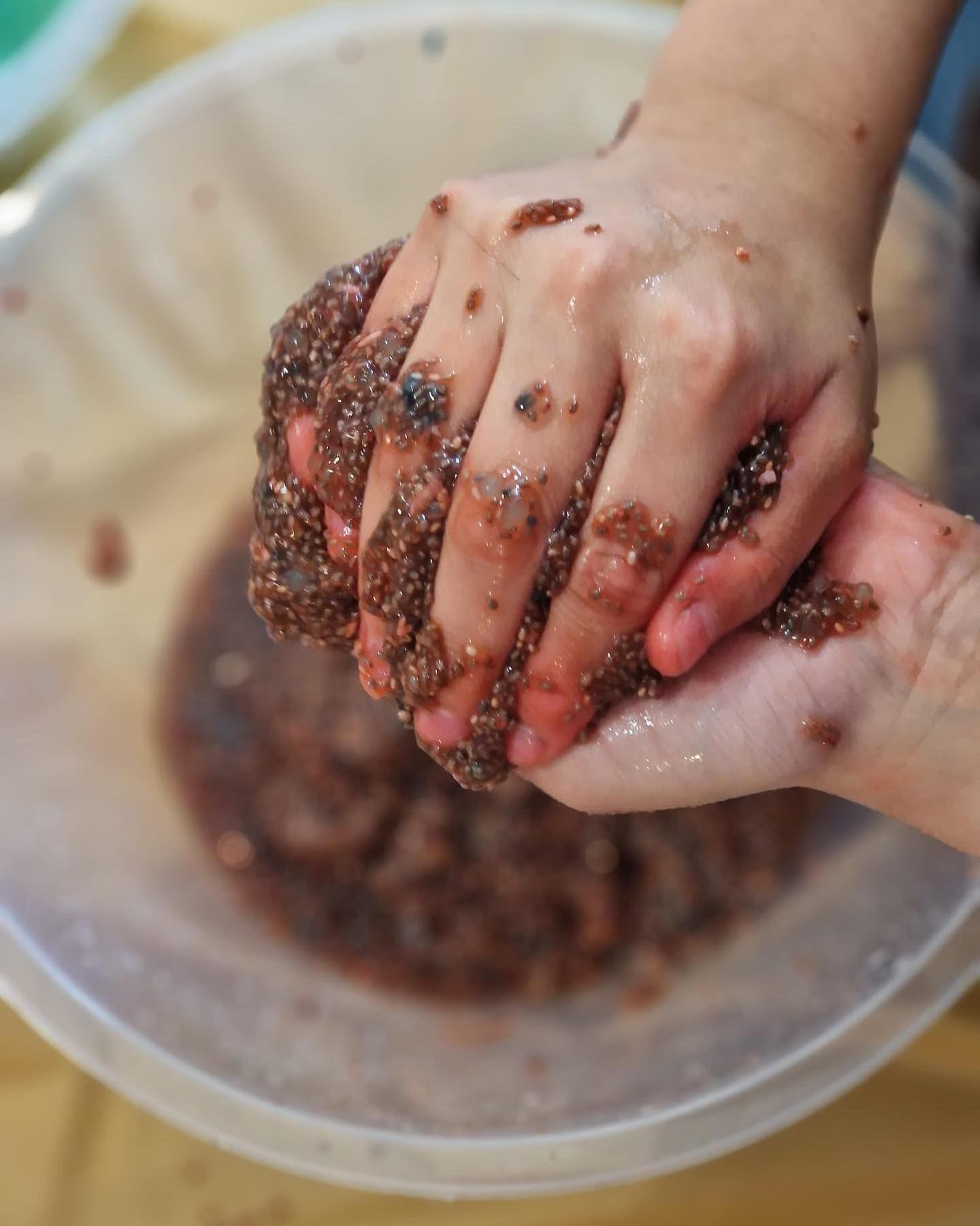 Kid is playing with some soft and sticky dough.