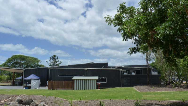 Dark-colored Modern Building With Low Angled Roof — Vision Roofing Fascia & Gutter in Hervey Bay, QLD
