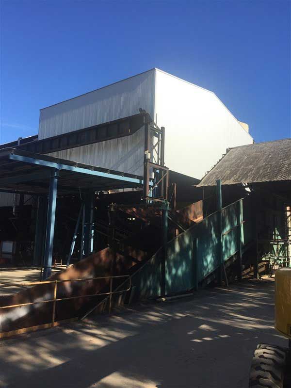 A Large Industrial Building With a Conveyor Belt System — Vision Roofing Fascia & Gutter in Hervey Bay, QLD