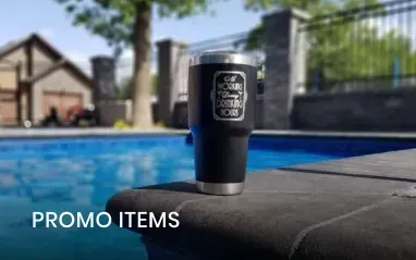Black tumbler with text sits by a pool.