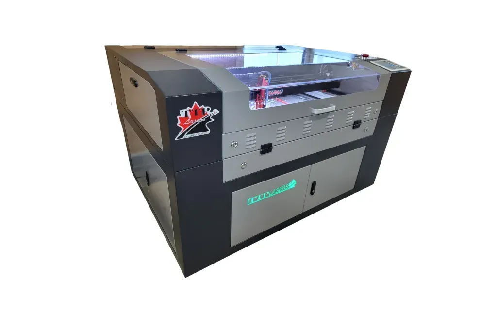 Laser engraver machine, gray and black with a clear top, in a workshop setting.
