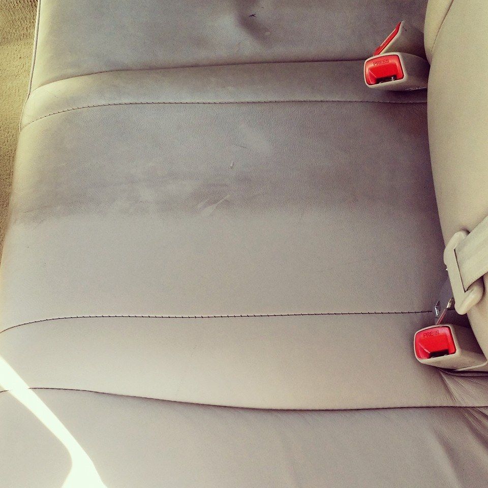 A close up of a car seat with red seat belts
