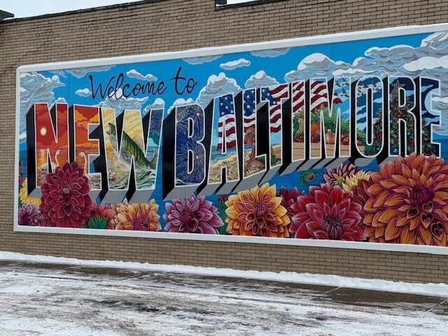 Mural on brick wall says