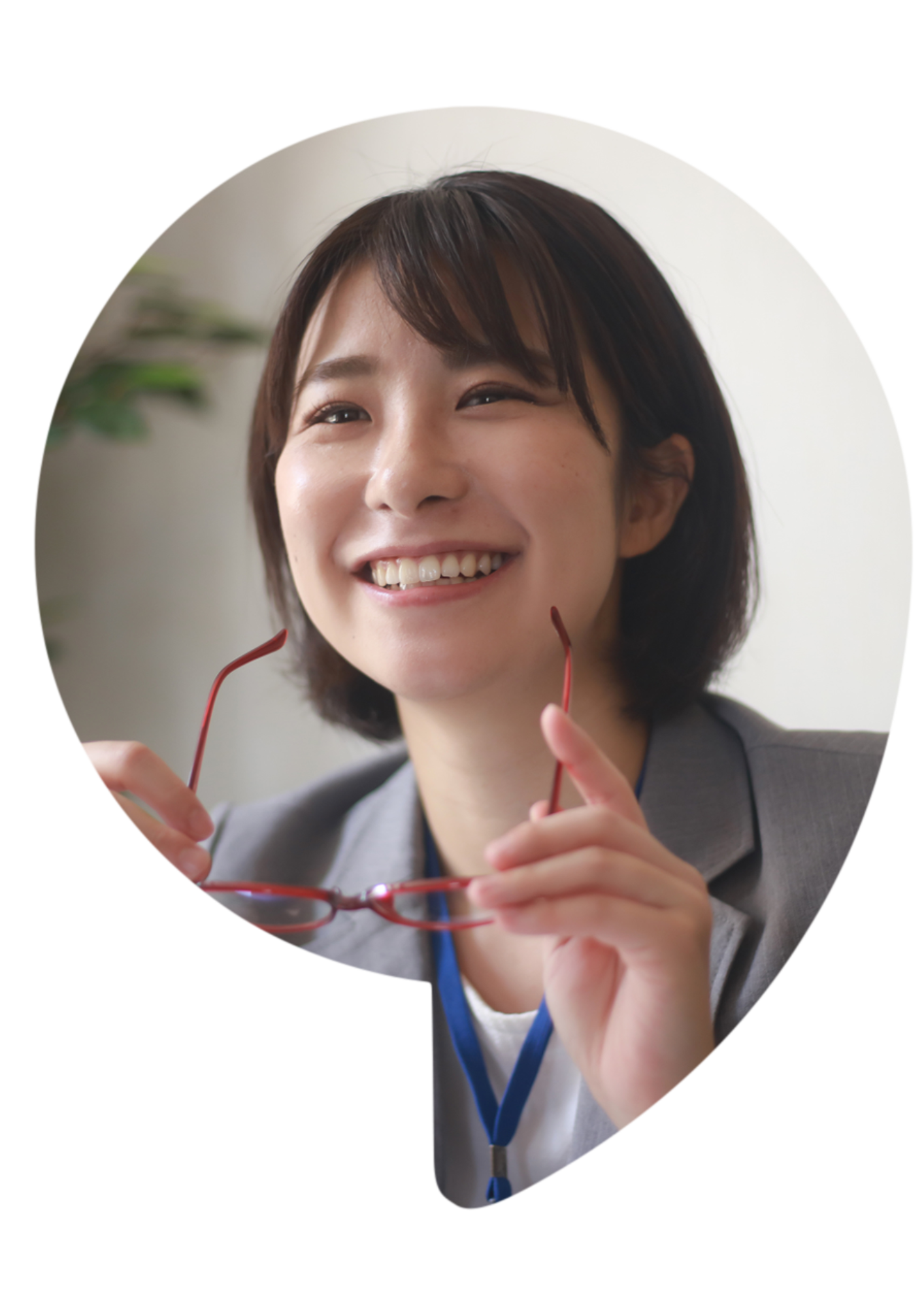 Woman smiling, holding glasses, wearing a blazer. In a speech bubble shape.
