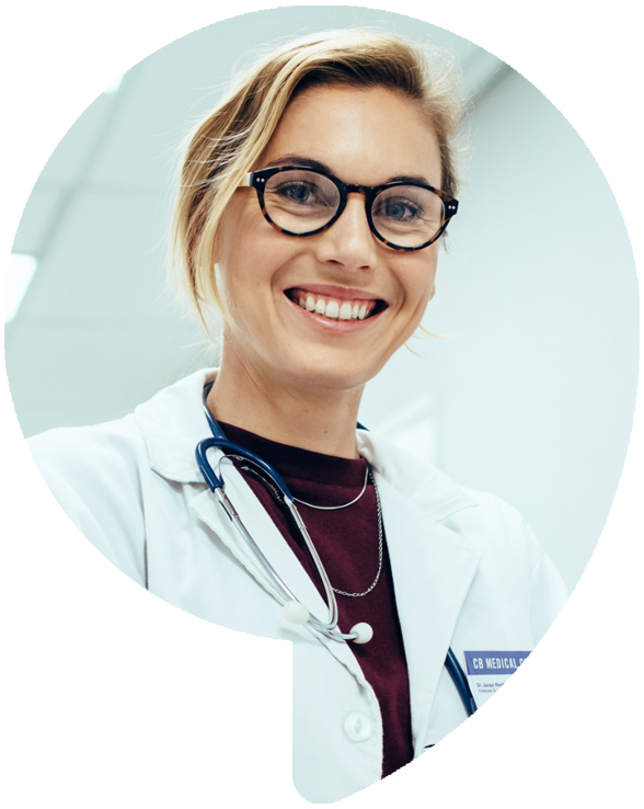 Smiling doctor in glasses, stethoscope, and white coat.