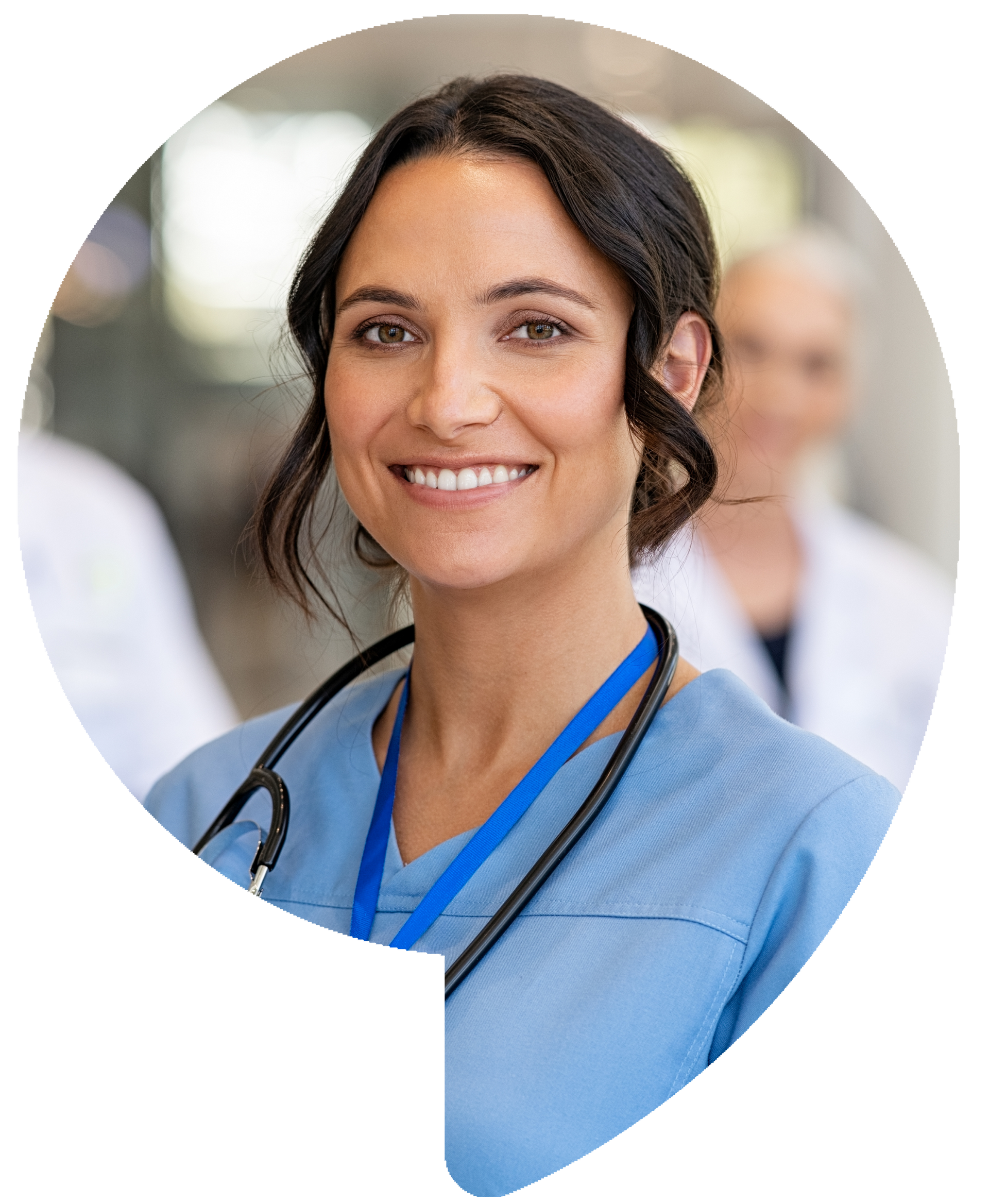 Nurse smiling, wearing scrubs and stethoscope, with colleagues in the background.