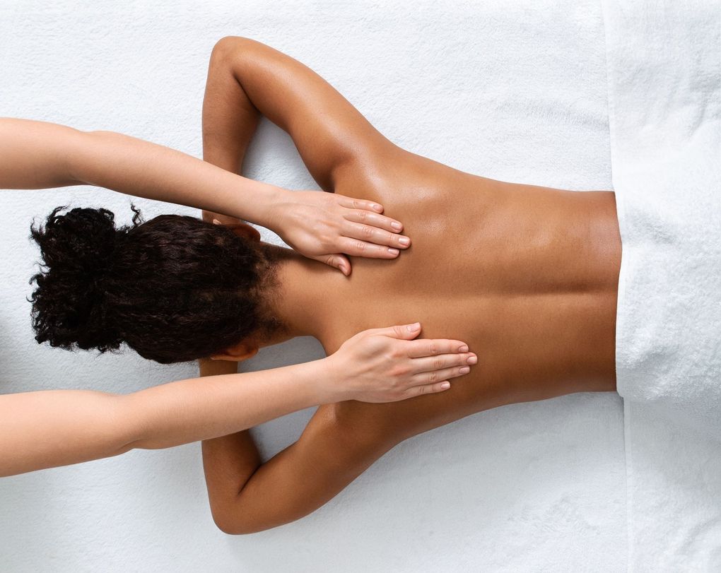 A woman is getting a massage on her back at a spa.