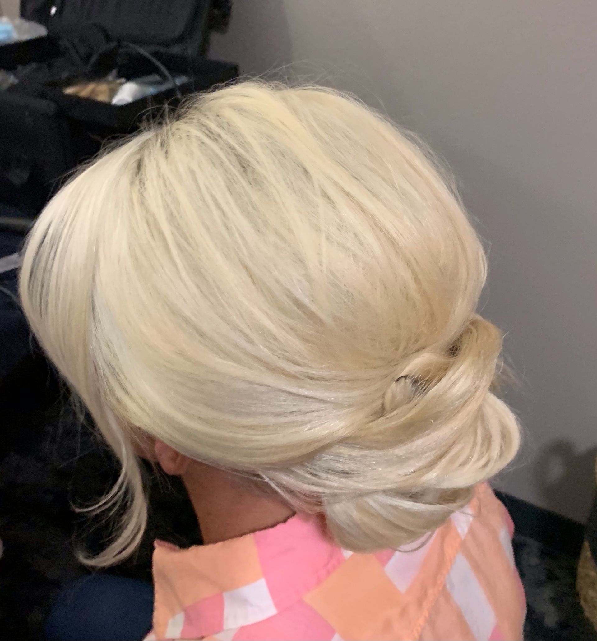 A woman with blonde hair in a bun is sitting in a room.