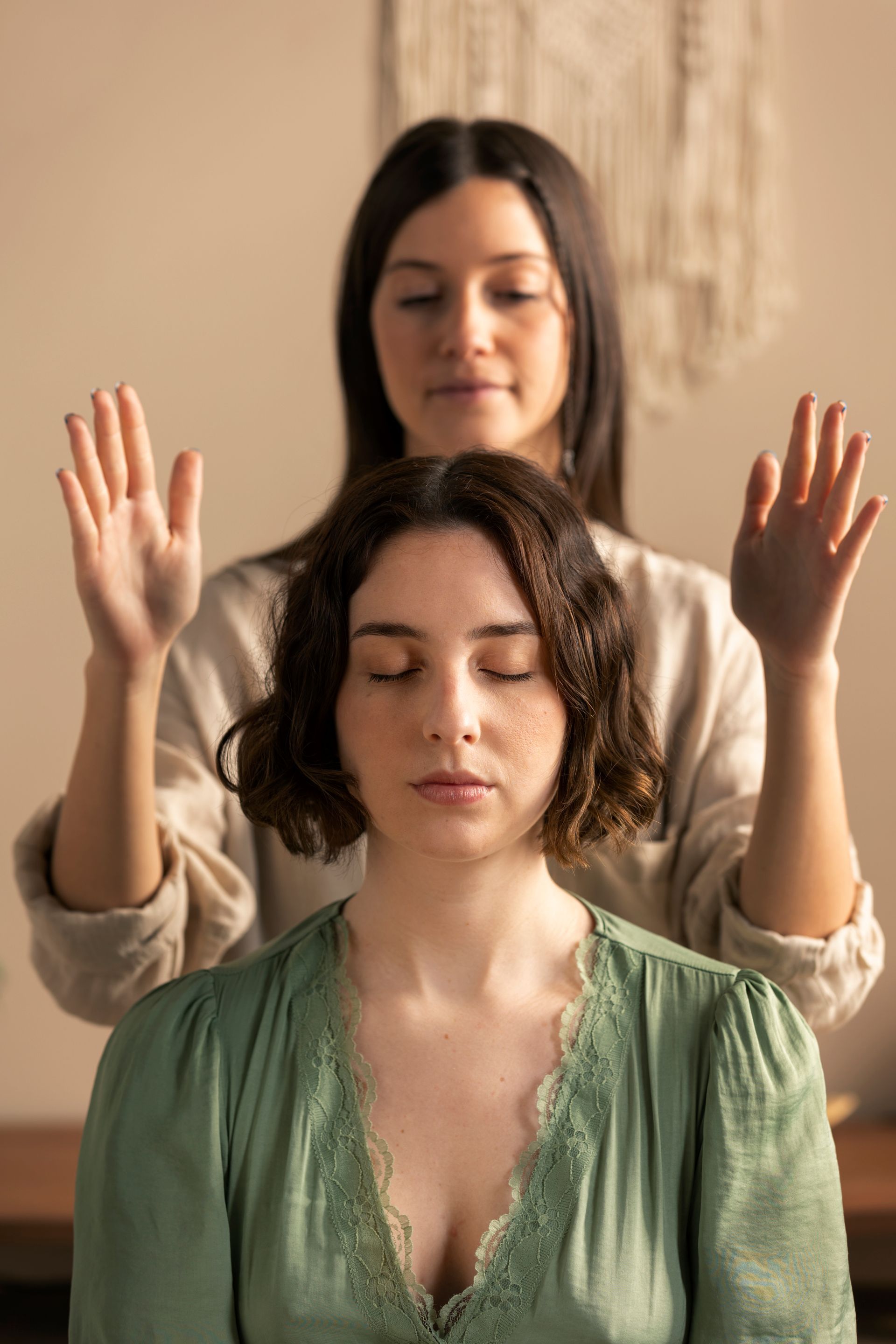 A woman is giving a healing session to another woman.