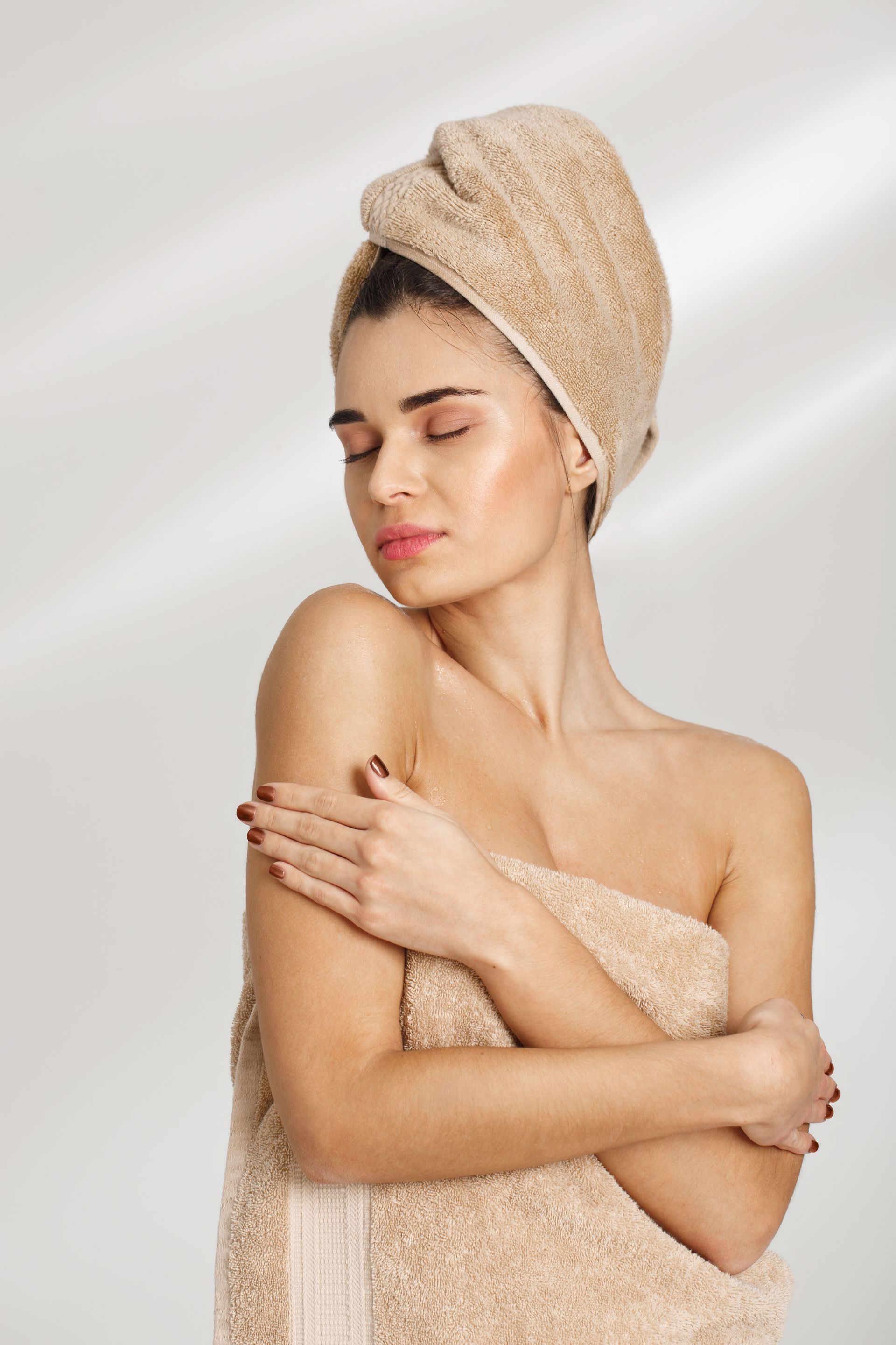 A woman wrapped in a towel with a towel wrapped around her head.