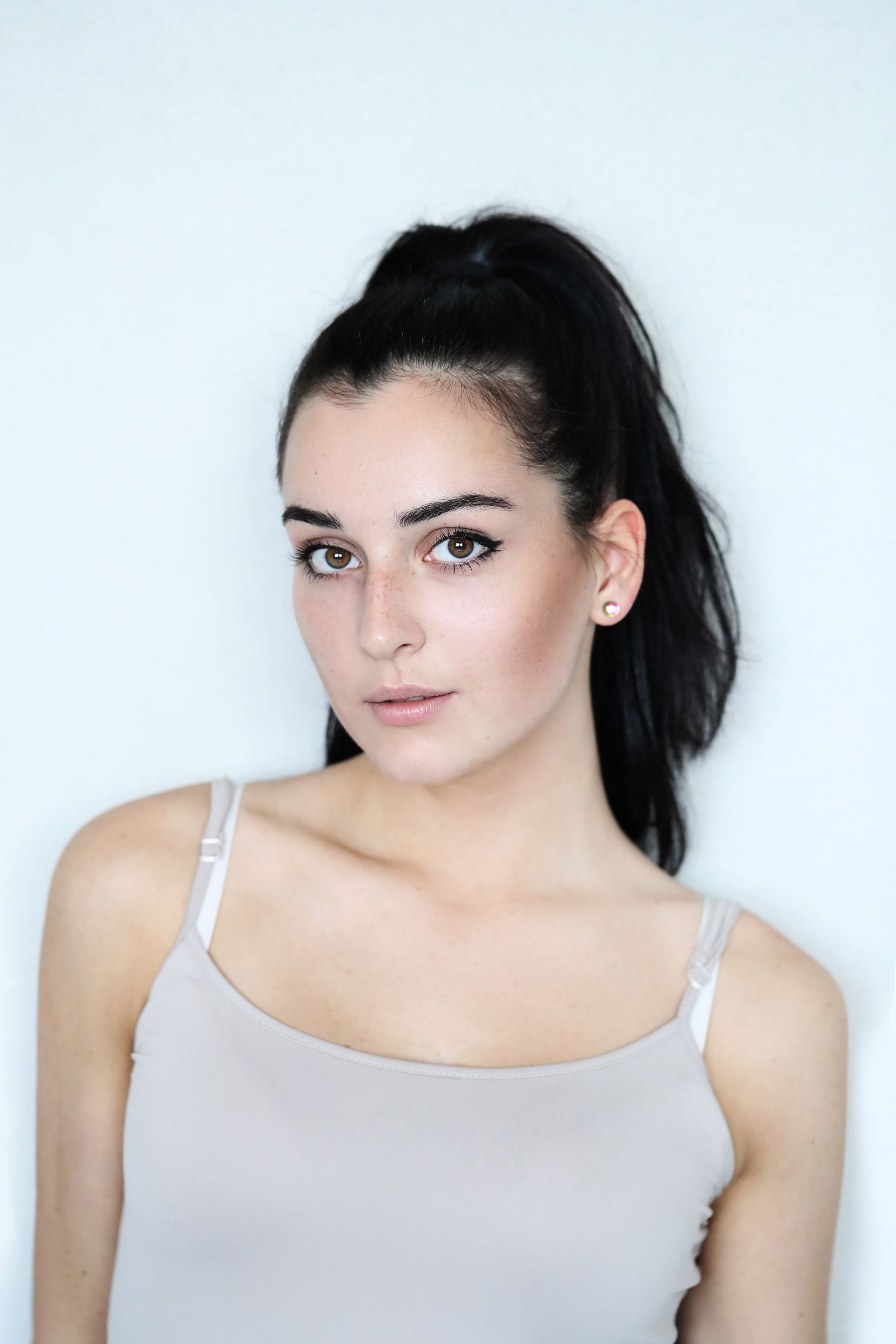 The woman is wearing a tank top and a ponytail.