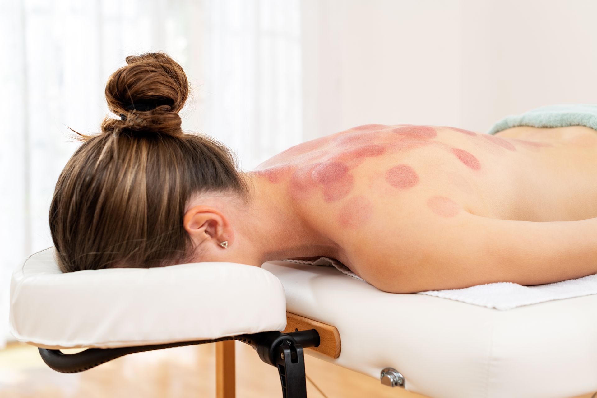 A woman is laying on a table getting a massage.