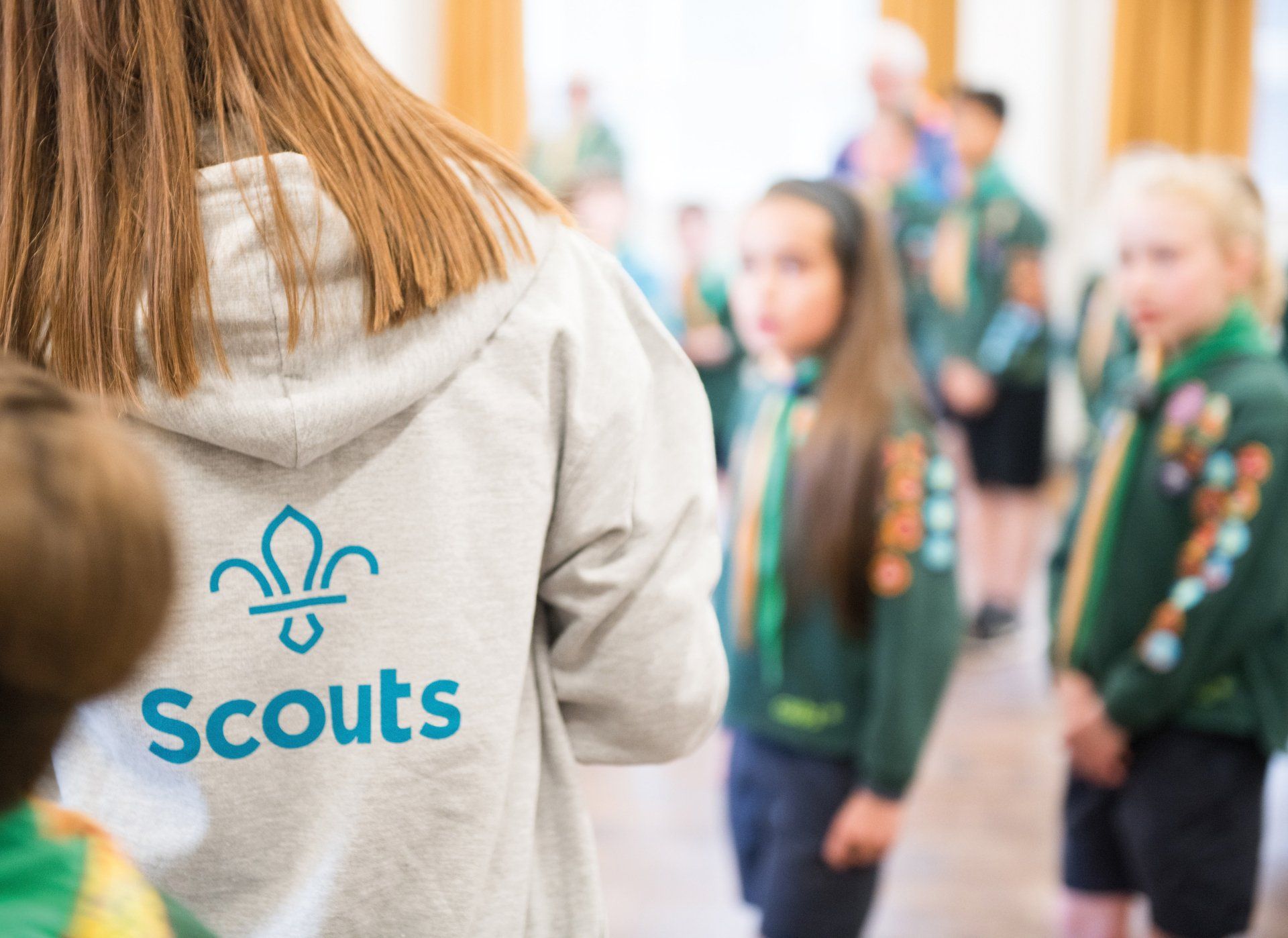 A girl is wearing a sweatshirt with the word scouts on it.