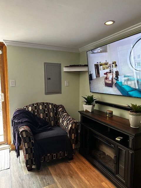 Cozy living room with striped armchair, fireplace, and large wall-mounted TV above a mantel