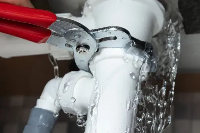 A person is fixing a leaking pipe with a wrench. — Elgin, IL — All Suburban Emergency Plumbing A person is fixing a leaking pipe with a wrench. — Elgin, IL — All Suburban Emergency Plumbing