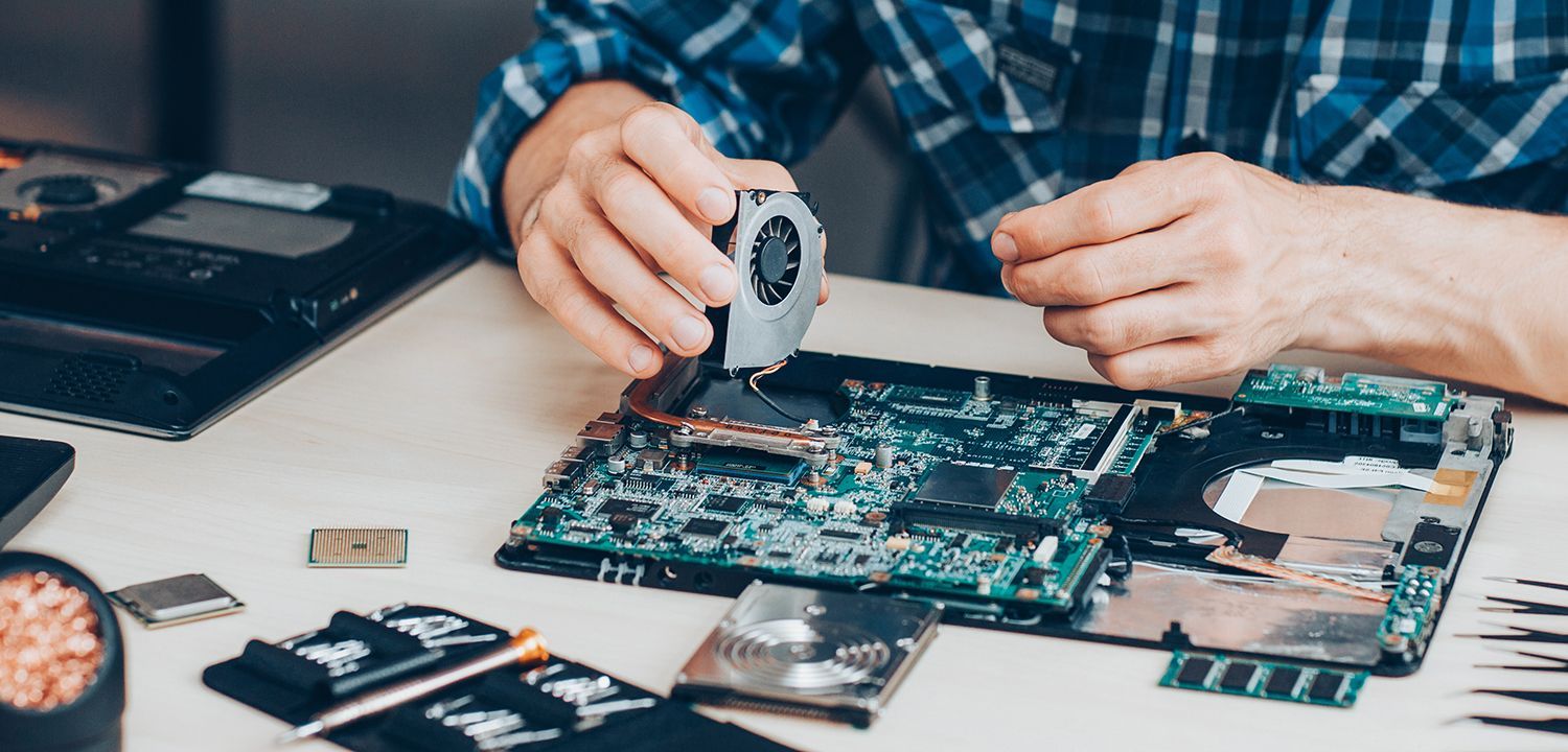 Cropped shot of a technician fixing a laptop cooler, showcasing an Apple MacBook repair.