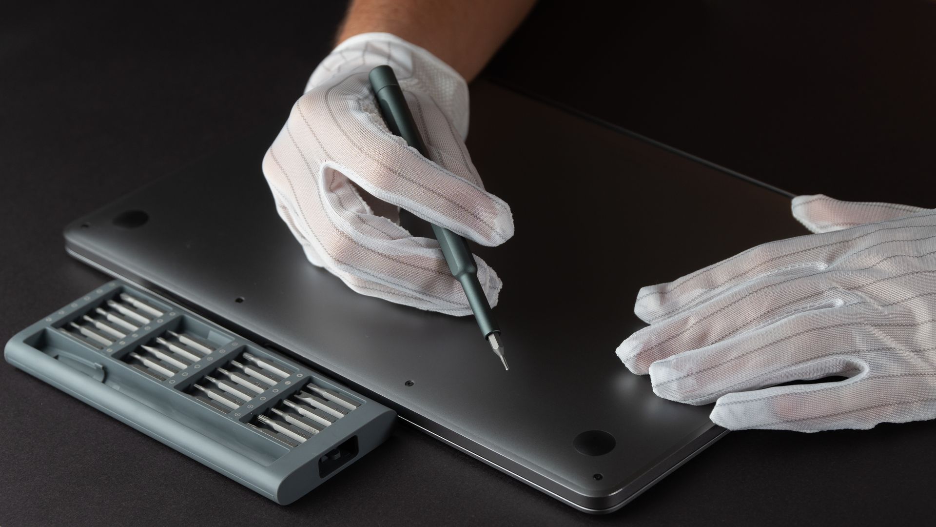 A technician is working on a MacBook.