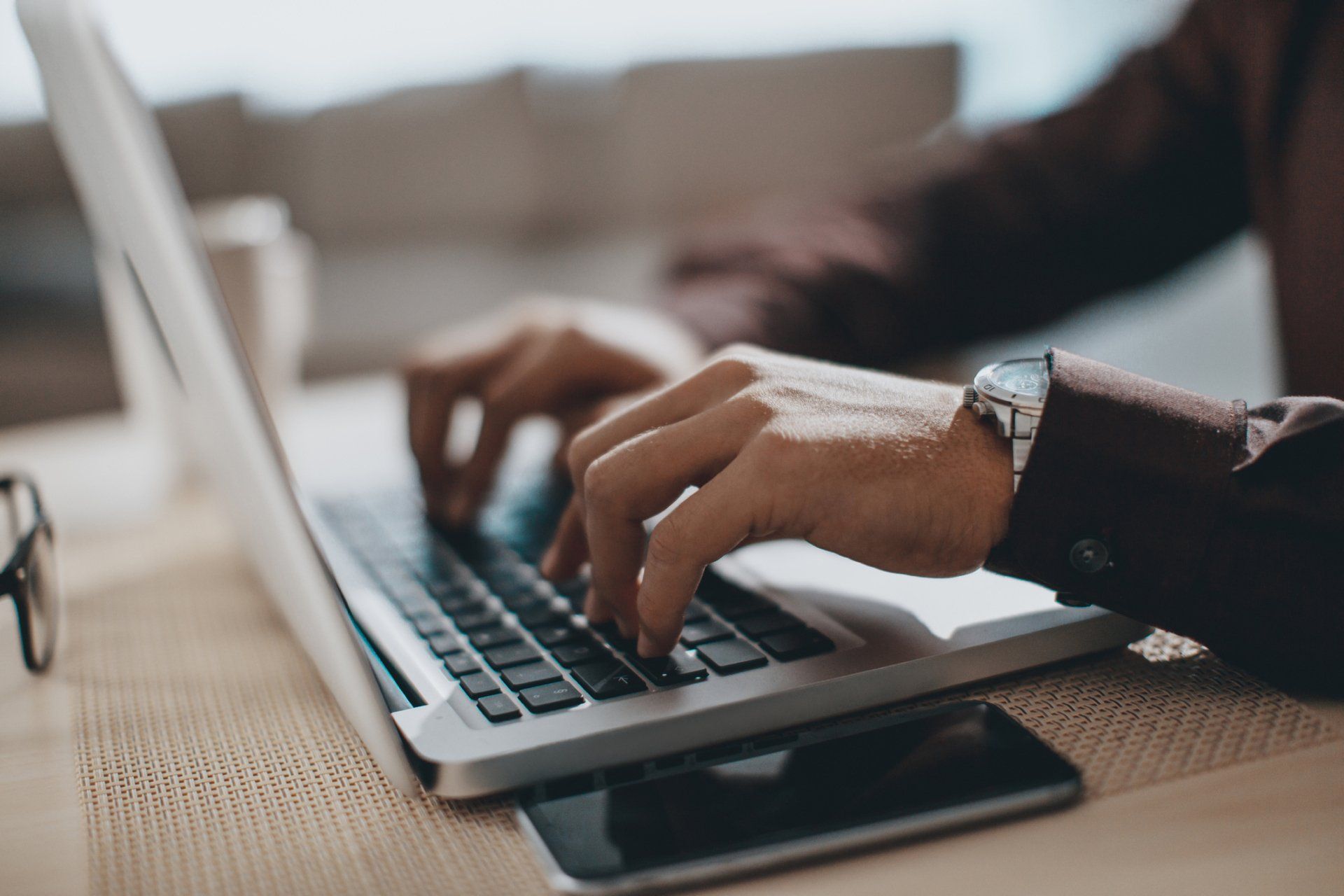A person with a watch playing on a laptop | Sydney, NSW | Always Apples A person in need of Apple technical support in Sydney