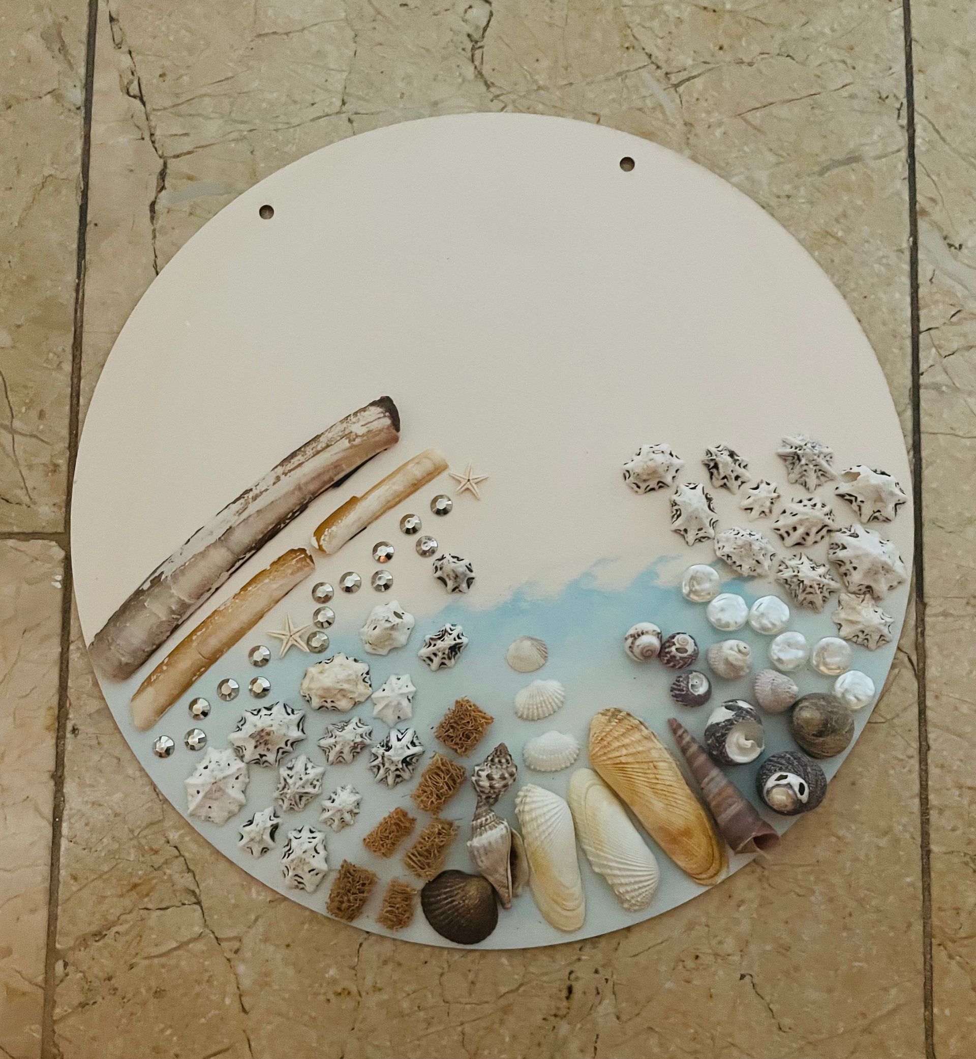 Ronde creatie met schelpen in een prachtige blauwe zee.