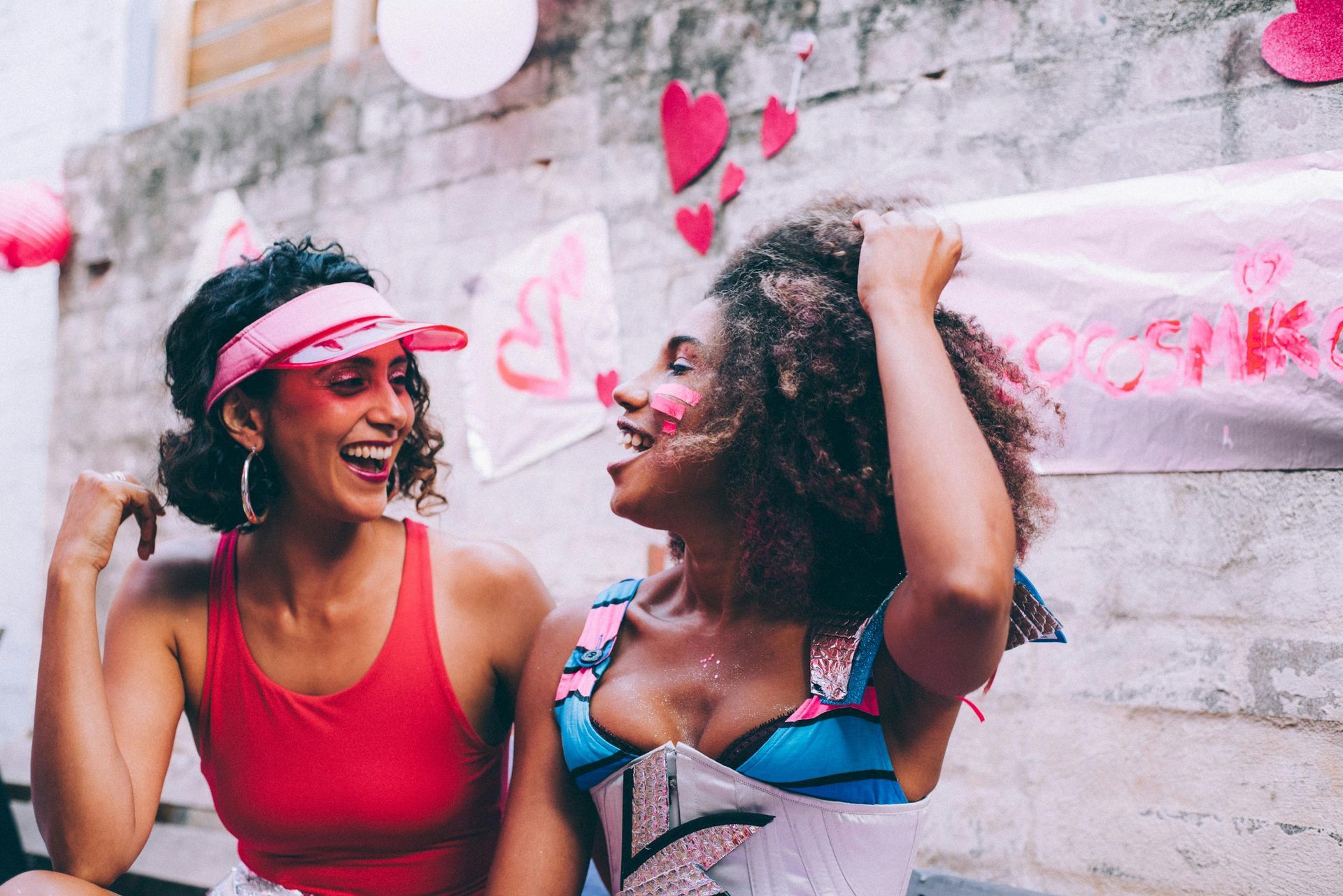 Two women smiling and laughing; party decorations in the background.